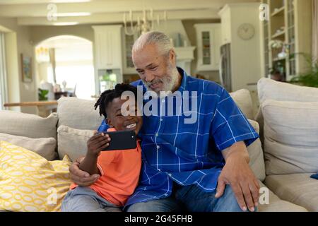 Uomo di razza misto senior con suo nipote che prende un selfie Foto Stock