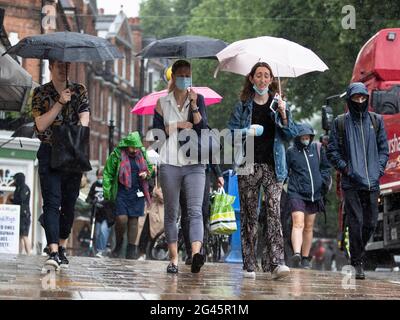 La gente cammina attraverso la pioggia torrenziale a Hampstead, Londra del nord mentre il tempo bagnato termina l'ondata di caldo del Regno Unito in giugno, 2021 Foto Stock