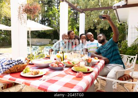 Famiglia afroamericana che prende un selfie nel giardino Foto Stock