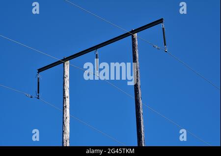 Bella vista luminosa delle linee elettriche aeree su vecchio pilastro di legno catturato contro cielo blu perfettamente chiaro, Ballycorus, Co. Dublino Foto Stock