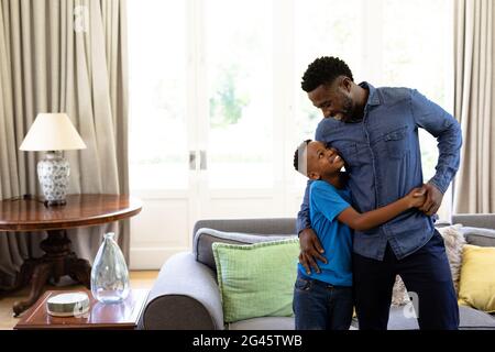 Uomo afro-americano godendosi il suo tempo a casa con suo figlio Foto Stock