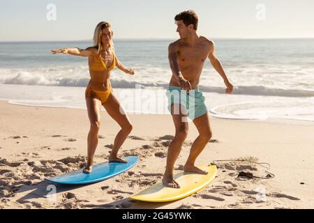 Giovane coppia che naviga in spiaggia Foto Stock