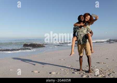 Coppia felice prendendo un selfie sulla spiaggia Foto Stock