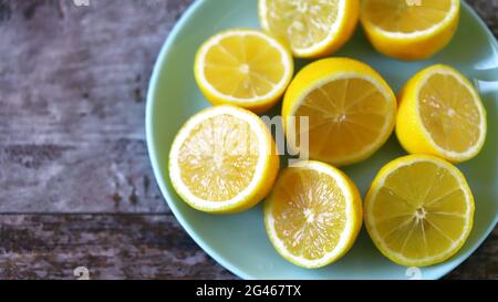 Piatto con limoni freschi. Limoni dimezzati su un piatto. Concetto di vitamine. Foto Stock