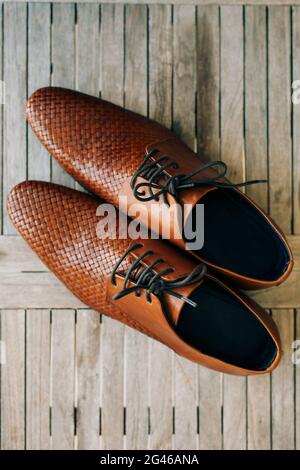 Scarpe uomo marrone con lacci su sfondo di legno Foto Stock