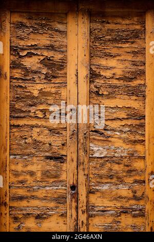 Un vecchio ingresso con doppio portone in metallo, sbucciato in legno Foto Stock