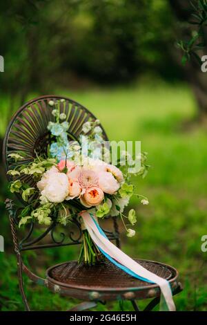 Bouquet nuziale di peonie su una sedia in metallo d'epoca Wedding in M Foto Stock