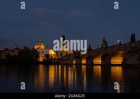 Vista notturna sul lungofiume del Ponte Carlo illuminato, del Castello di Praga e della Cattedrale di San Vito a Praga, Repubblica Ceca Foto Stock