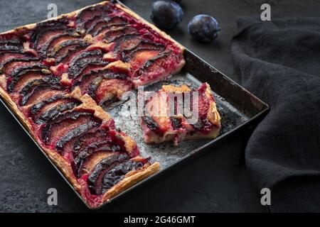 Tarte aux prugne tradizionali francesi con prugne dolci e vaniglia offerto come closeup su un vassoio di metallo rustico Foto Stock