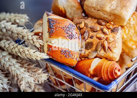 Assortimento di pane e panini tradizionali con grani su tavola di legno. Vista dall'alto. Foto Stock