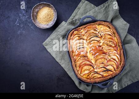 Tarte francese tradizionale di mele offerto come vista dall'alto su una padella di ghisa di design con spazio di copia a sinistra Foto Stock