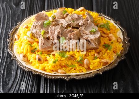 Jordan National Dish Mansaf fatto di carne di agnello yogurt magro, chiodo di riso nel piatto sul tavolo. Orizzontale Foto Stock