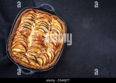 Tradizionale tarte francese di mele offerto come vista dall'alto su una padella di ghisa di design con spazio copia a destra Foto Stock
