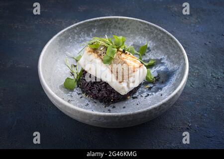 Filetto di merluzzo fritto in stile moderno con lattuga portulaca Foto Stock