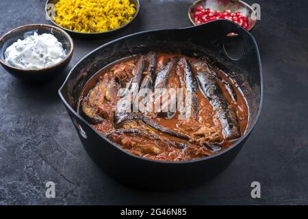 In stile moderno, lo stufato di melanzane di agnello persiano khoresh bademjan cotto lentamente viene servito con riso e yogurt da vicino in un recipiente di design Foto Stock