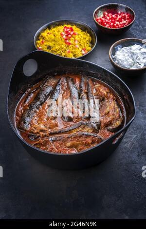 In stile moderno, lo stufato di melanzane di agnello persiano khoresh bademjan cotto lentamente e servito con riso e yogurt come vista dall'alto in un recipiente di design Foto Stock