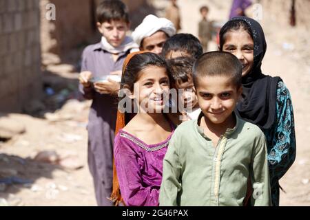 Islamabad, Pakistan. 19 giugno 2021. I bambini afghani rifugiati posano per una foto in una baraccopoli alla vigilia della Giornata Mondiale dei rifugiati, alla periferia di Islamabad, Pakistan, il 19 giugno 2021. Secondo l’Alto Commissariato delle Nazioni Unite per i rifugiati (UNHCR), il Pakistan ospita attualmente più di 1.4 milioni di rifugiati afghani registrati che sono stati costretti a fuggire dalle loro case. Credit: Ahmad Kamal/Xinhua/Alamy Live News Foto Stock