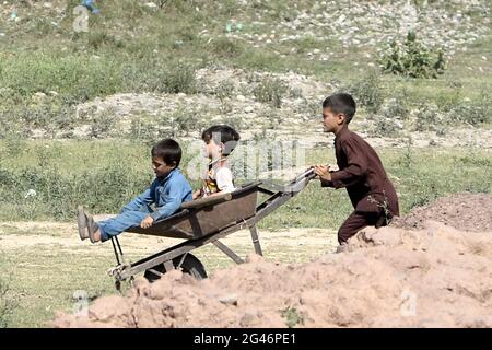 Islamabad, Pakistan. 19 giugno 2021. I bambini rifugiati afghani giocano in una baraccopoli alla vigilia della Giornata Mondiale dei rifugiati, alla periferia di Islamabad, Pakistan, il 19 giugno 2021. Secondo l’Alto Commissariato delle Nazioni Unite per i rifugiati (UNHCR), il Pakistan ospita attualmente più di 1.4 milioni di rifugiati afghani registrati che sono stati costretti a fuggire dalle loro case. Credit: Ahmad Kamal/Xinhua/Alamy Live News Foto Stock