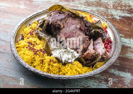 Shuwa agnello Omani cotto lentamente rivestito in strofinamento di spezie e avvolto in foglie di banana servito con riso e yogurt come primo piano su a. Foto Stock