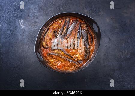 In stile moderno, stufato di melanzane di agnello persiano cucinato lentamente, khoresh bademjan servito da primo piano in una pentola di design su una tavola rustica con c. Foto Stock