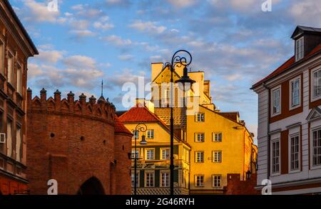 Gli edifici storici e le pareti in mattoni rossi di Varsavia Polonia Barbican al tramonto in primavera Foto Stock