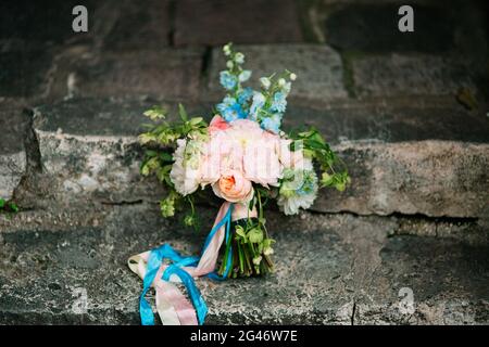 Bouquet nuziale di peonie sulle rocce. Matrimonio in Montenegro, Foto Stock