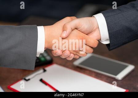 Uomini d'affari aziendali Handshake Indoors.Two persone professionalmente ben vestito gesturing togetherness.Working colleghi Partners Foto Stock