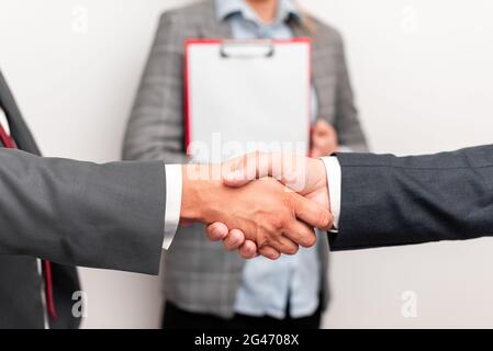 Uomini d'affari aziendali Handshake Indoors.Two persone professionalmente ben vestito gesturing togetherness.Working colleghi Partners Foto Stock