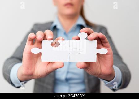 Welldressed Business Woman tenendo due pezzi di Jigsaw Puzzle, professionale Adult Women Resolving Missing Ideas, strategia per N Foto Stock