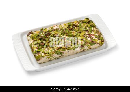 Piatto con tradizionale halva di pistacchio turco su un piatto da vicino isolato su sfondo bianco Foto Stock