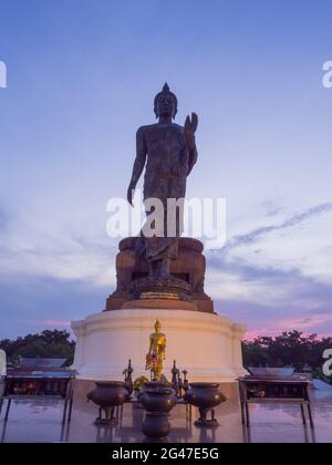 La statua di bronzo del buddha Grande Walking è la statua principale di Phutthamonthon (provincia buddista) a Nakornpathom, Thailandia, al crepuscolo Foto Stock