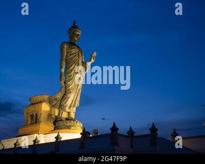 La statua di bronzo del buddha Grande Walking è la statua principale di Phutthamonthon (provincia buddista) a Nakornpathom, Thailandia, al crepuscolo Foto Stock