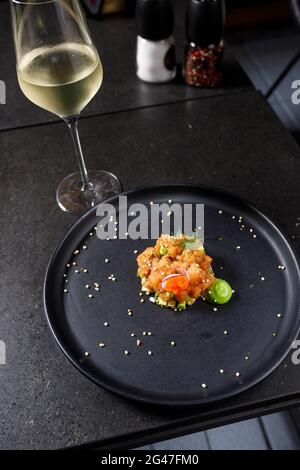 Tartare di salmone con avocado, cipolla primaverile, pomodoro e caviale Foto Stock