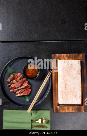 Tataki di manzo servito su sale caldo con salsa Foto Stock