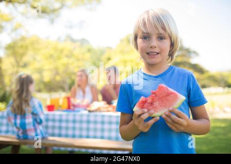Ragazzo sorridente holding anguria nel parco Foto Stock