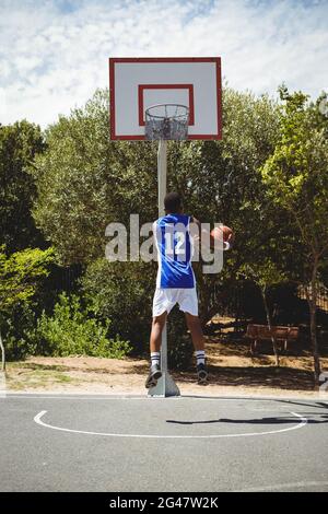 Teenage giocatore di basket punteggio mentre si pratica in campo Foto Stock