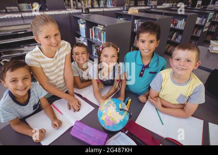 Schoolkids globo di studiare in biblioteca Foto Stock