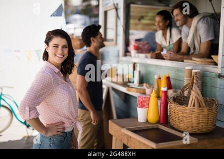 Ritratto di donna sorridente in piedi con la mano sul hip Foto Stock