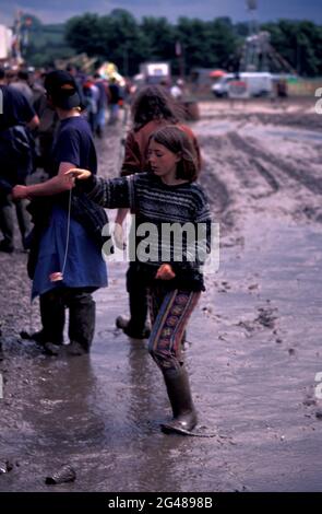 Ragazza che gioca con un Yo-yo in un festival Muddy Glastonbury 1998, Pilton, Somerset, Inghilterra Foto Stock