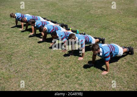 Vista ad alto angolo dei giocatori che fanno push up ats campo erboso Foto Stock