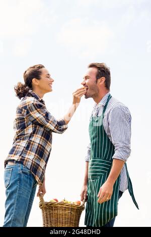 Donna sorridente che alimenta la mela all'uomo Foto Stock