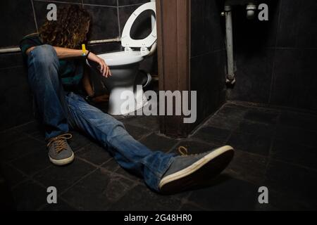 Uomo che vomita sulla tazza del water Foto Stock