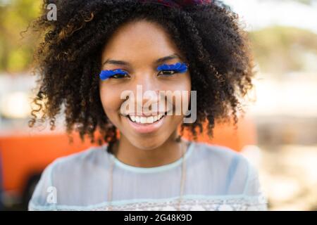 Primo piano ritratto di donna sorridente che indossa ciglia artificiali Foto Stock