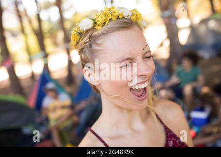 Giovane donna che grida con gli occhi chiusi al campeggio Foto Stock