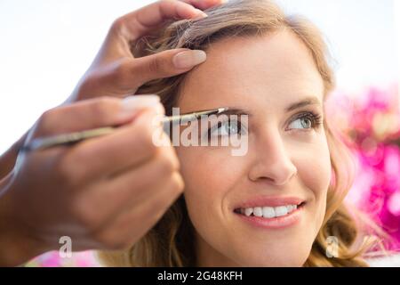 Mano ritagliata di estetista applicando trucco alla sposa Foto Stock