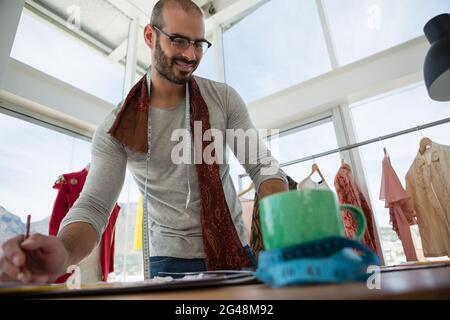 Vista ad angolo basso di un designer sorridente che lavora al tavolo Foto Stock