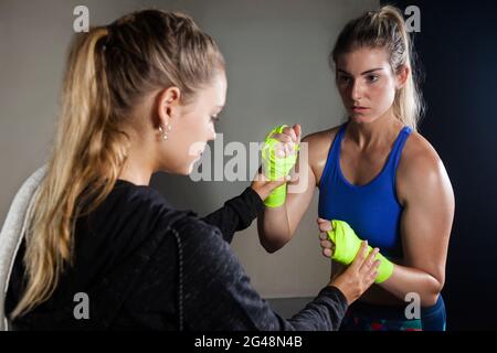 Allenatore che assiste la donna nella boxe Foto Stock
