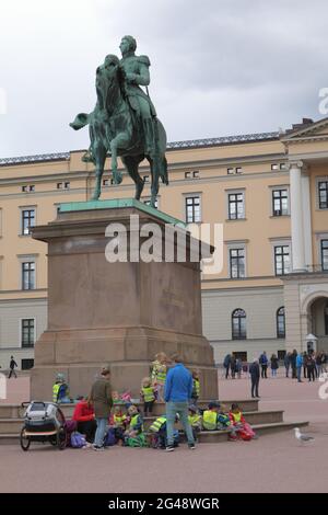 I bambini girano il gruppo riposandosi alla statua equestre del re Karl Johan di fronte al Palazzo reale di Oslo, Norvegia Foto Stock