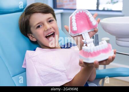 Ritratto del ragazzo carino che tiene la muffa dentale Foto Stock