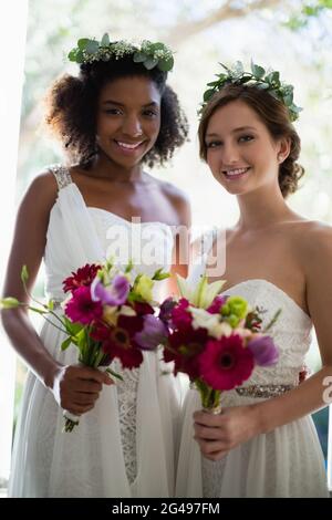 Sposa e le sue damigelle hanno piedi con bouquet a casa Foto Stock